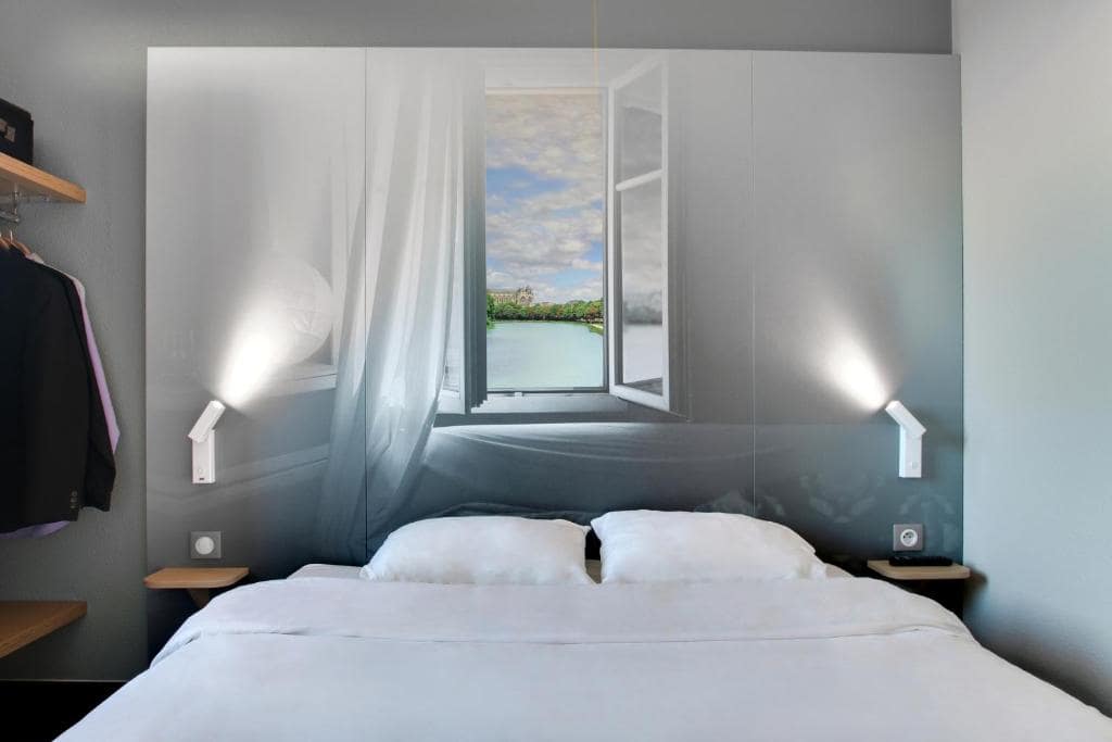 A bed in a room with a view of a window.