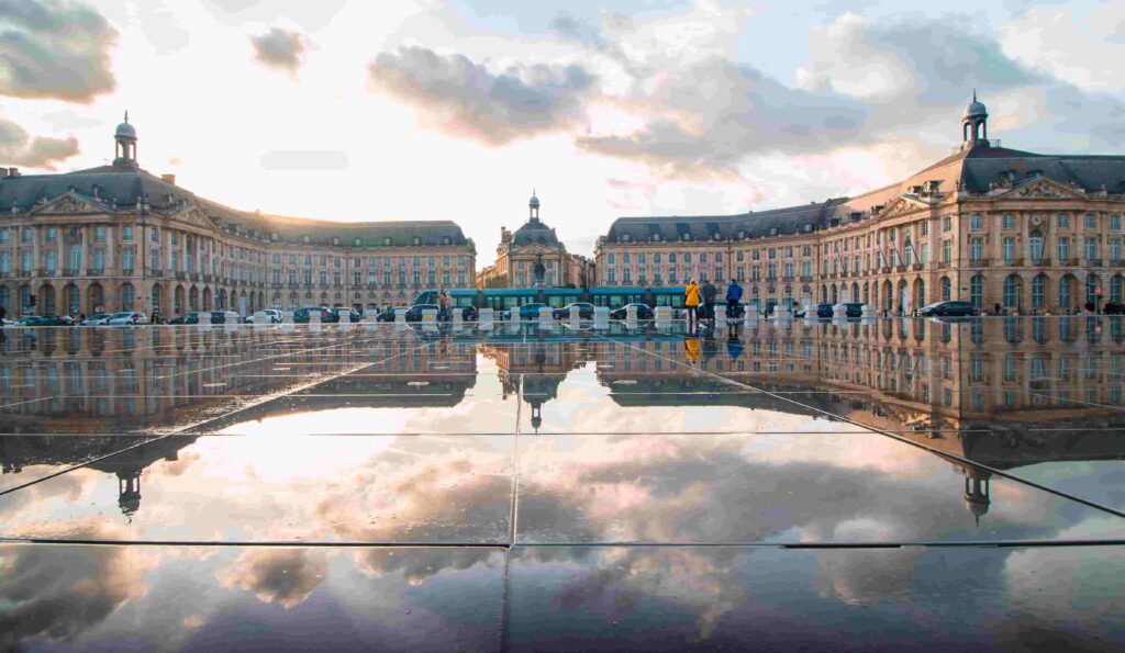 A building reflects in a puddle of water in France.