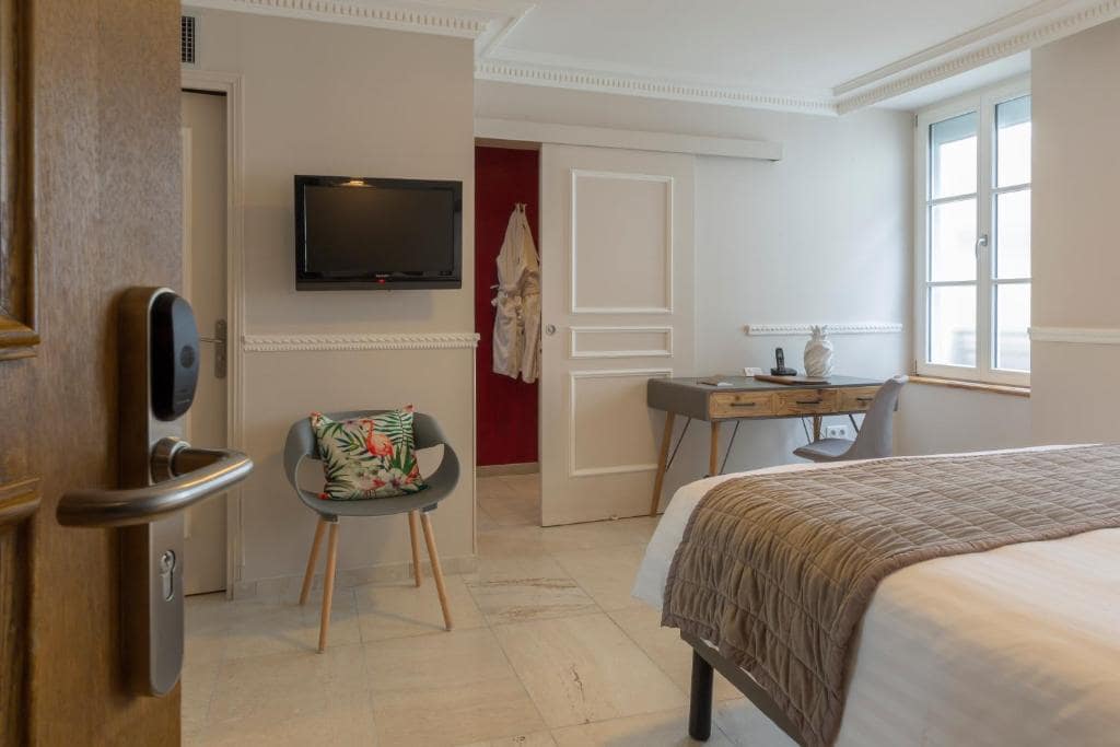 A hotel room with a bed and a tv.