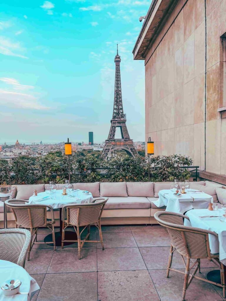 Outdoor dining area at the Eiffel Tower Restaurant with a view of the Eiffel Tower.