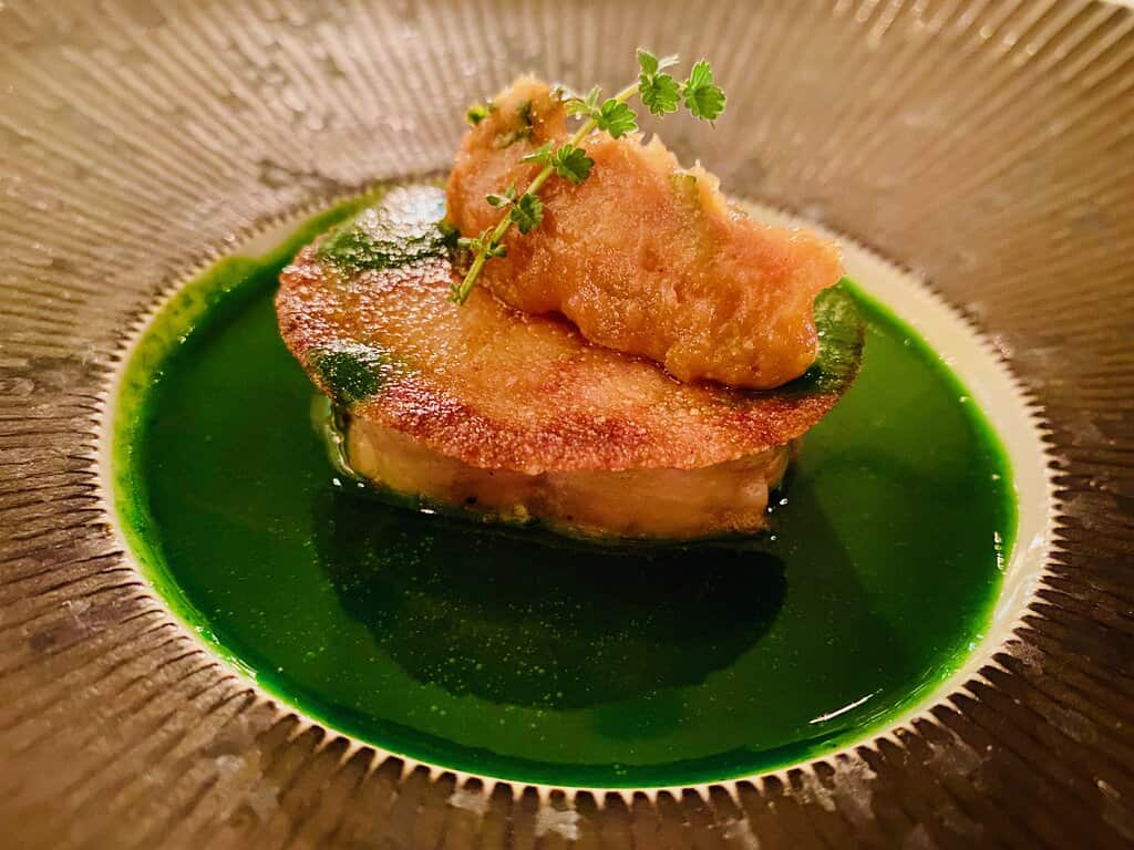 A dish with a green sauce on top served at a restaurant in Reims.