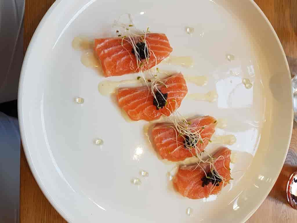 A plate of salmon on a wooden table at a restaurant in Reims.