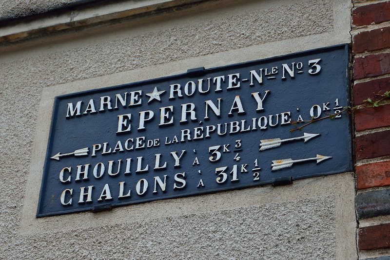 A sign on the side of a building that says marine route ne 3 epernay near Reims.