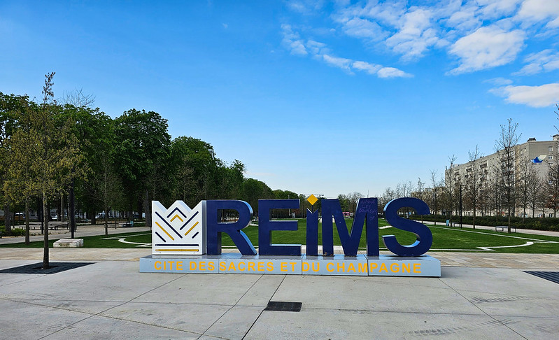 A sign that says riems in front of a park.