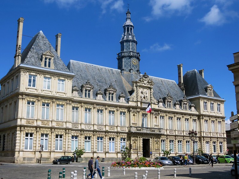 In the charming city of Reims, a magnificent building rises proudly with its iconic clock tower at its center.