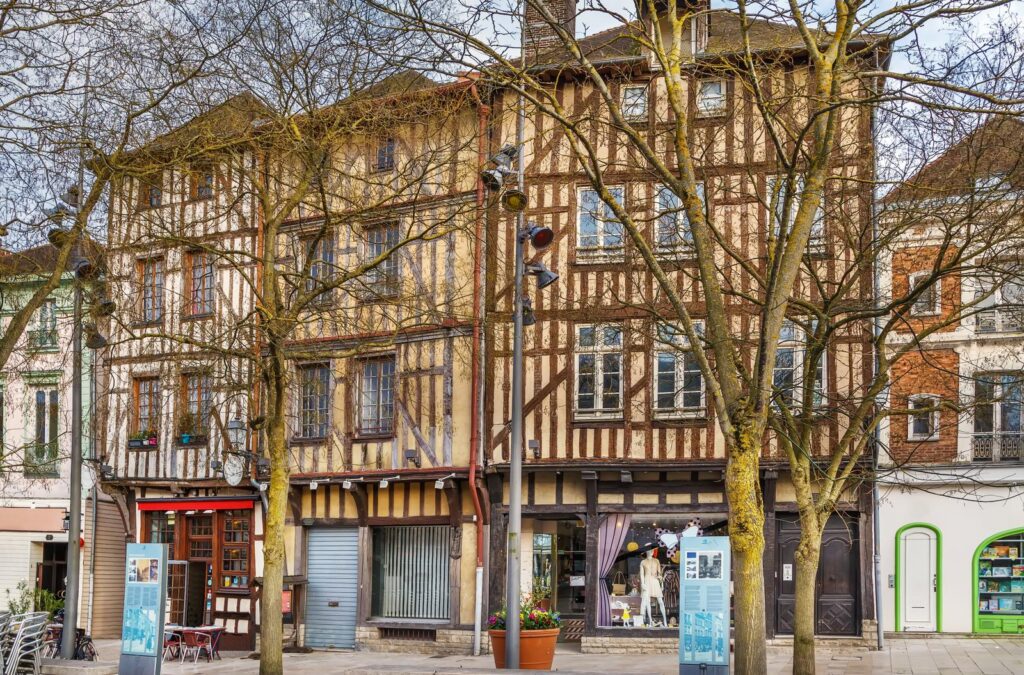 A row of old buildings in a town square, including the iconic Troyes Restaurant.