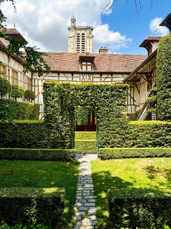 A courtyard with hedges and trees in front of a building.