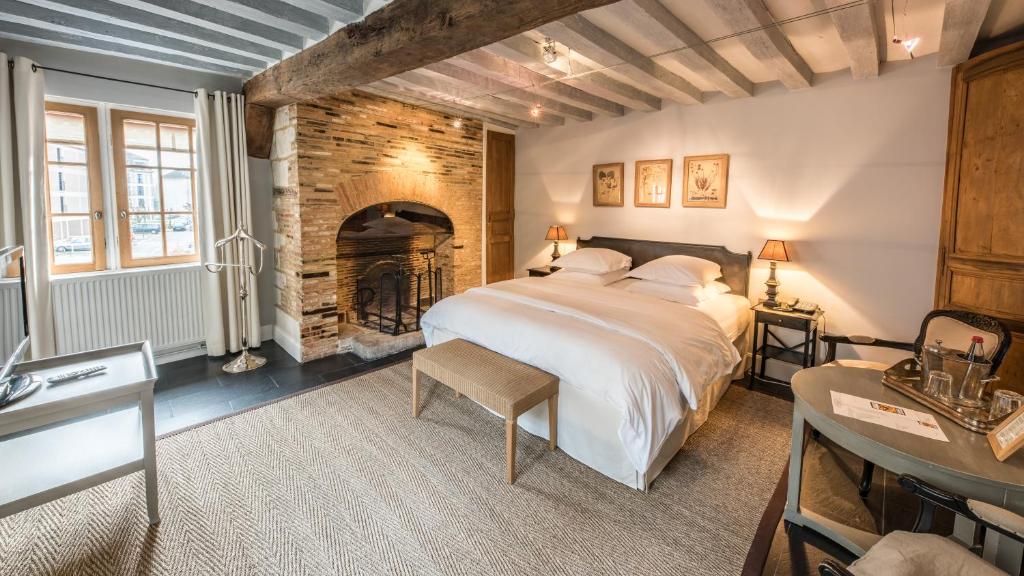 A bedroom with a bed and a fireplace.