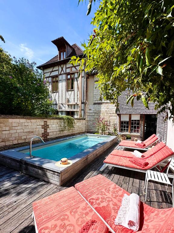 A house with a swimming pool and lounge chairs.