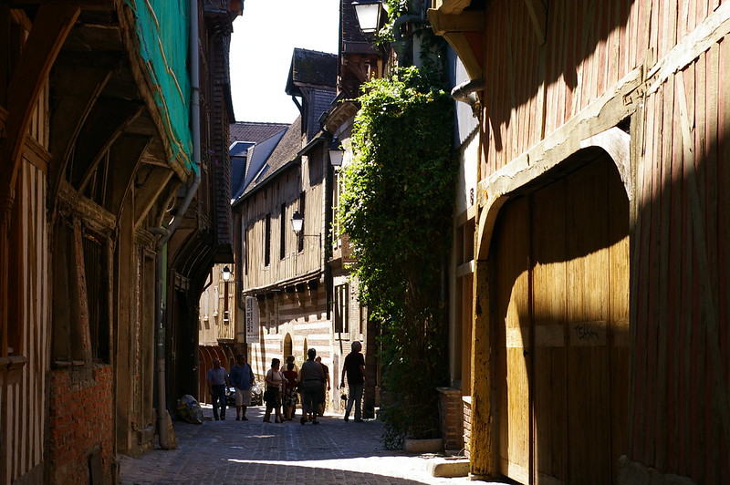 People walking down a cobblestone street.