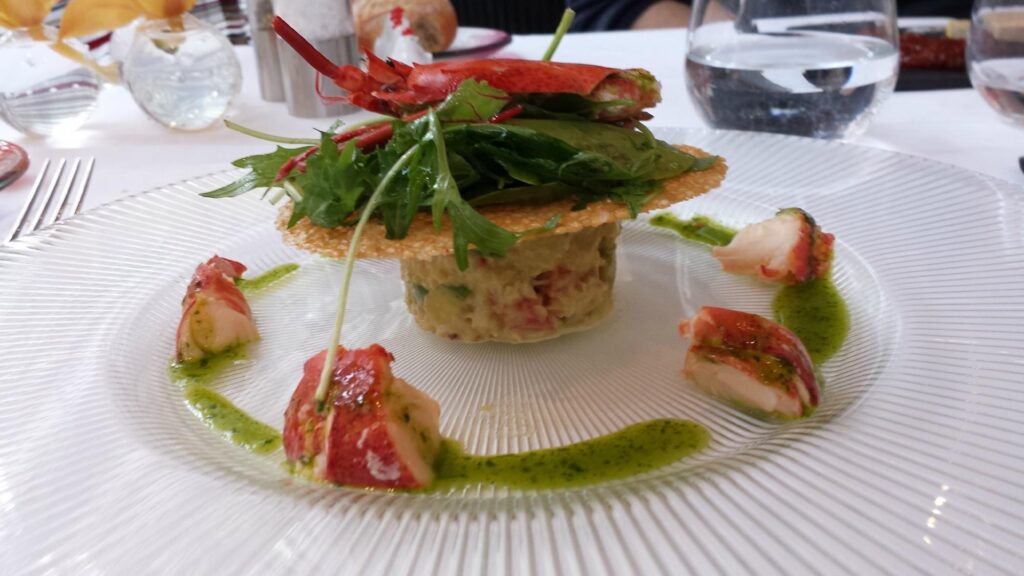 A white plate with a lobster from Troyes Restaurant on it.