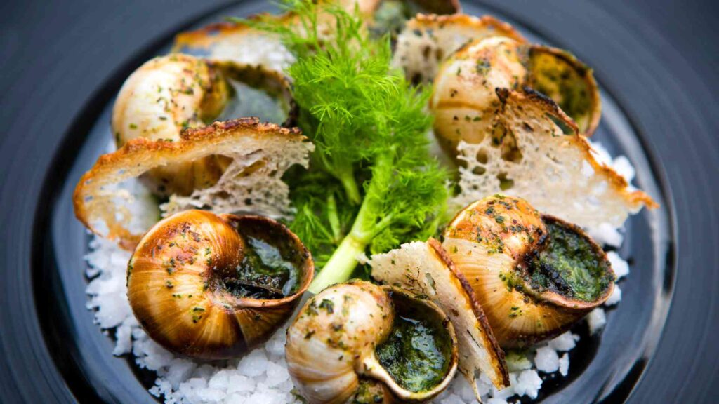 A plate of snails on a black plate.